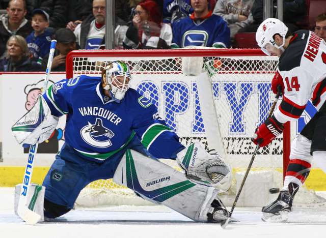 VANCOUVER, BC - JANUARY 15: Adam Henrique #14 of the New Jersey Devils attempts to deflect the puck past goaltender Jacob Markstrom #25 of the Vancouver Canucks during their NHL game at Rogers Arena January 15, 2017 in Vancouver, British Columbia, Canada. (Photo by Jeff Vinnick/NHLI via Getty Images)